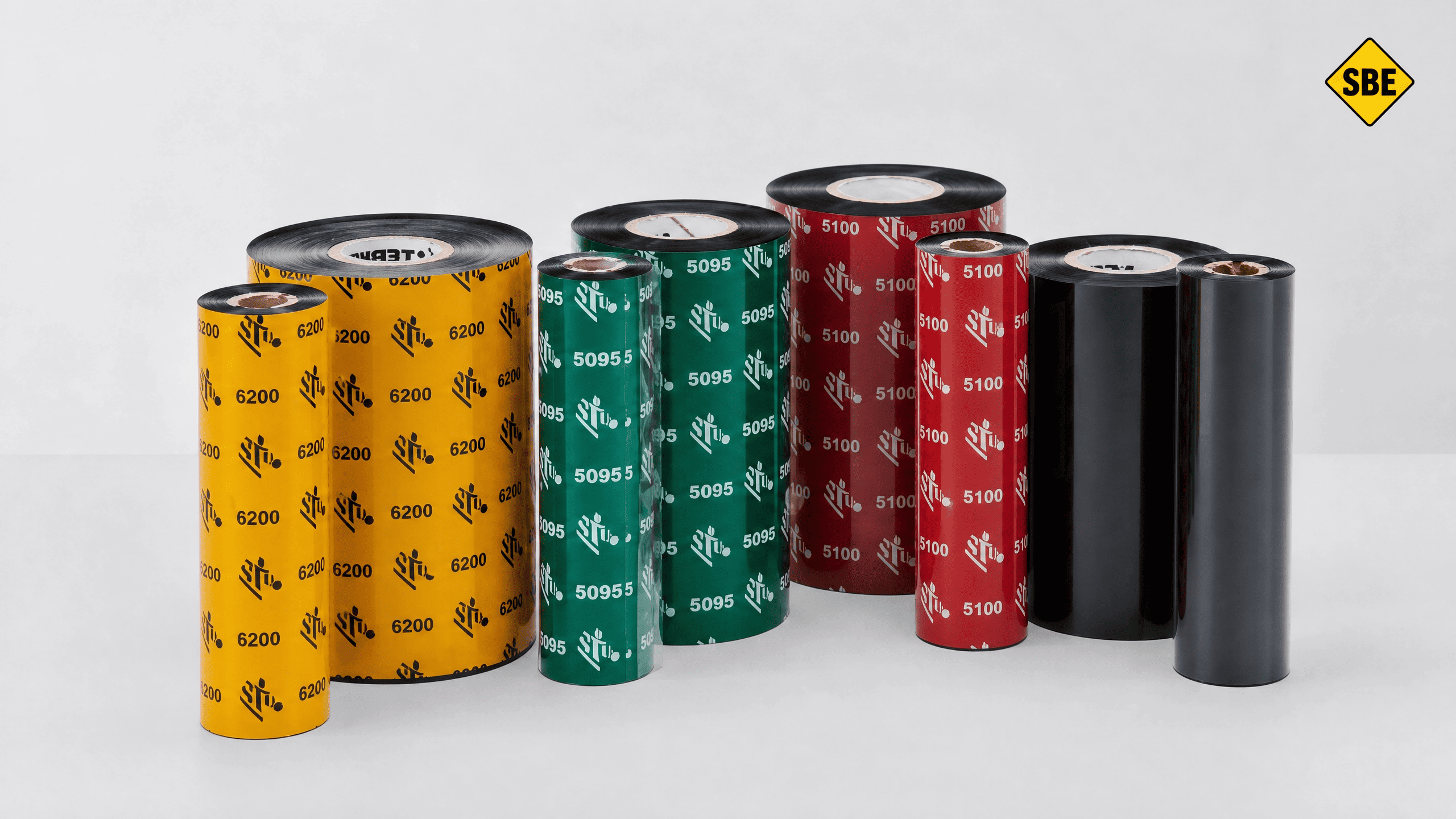 S&eacute;lection de rubans transfert thermique multicolores (noir, rouge, vert, jaune) pour l'impression d'&eacute;tiquettes industrielles haute performance.